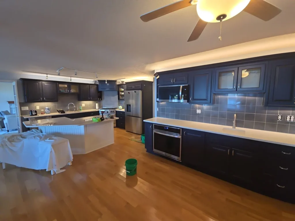 Remodeled kitchen with dark cabinets, quartz counters and tile backsplash by Stoney Creek Construction in Wolcottville, Indiana