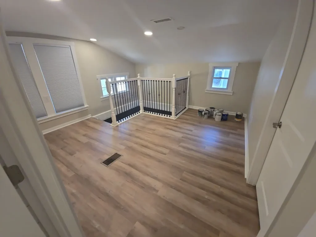 Renovated upstairs loft with new LVP flooring and iron baluster railing by Stoney Creek Construction in Rome City, Indiana
