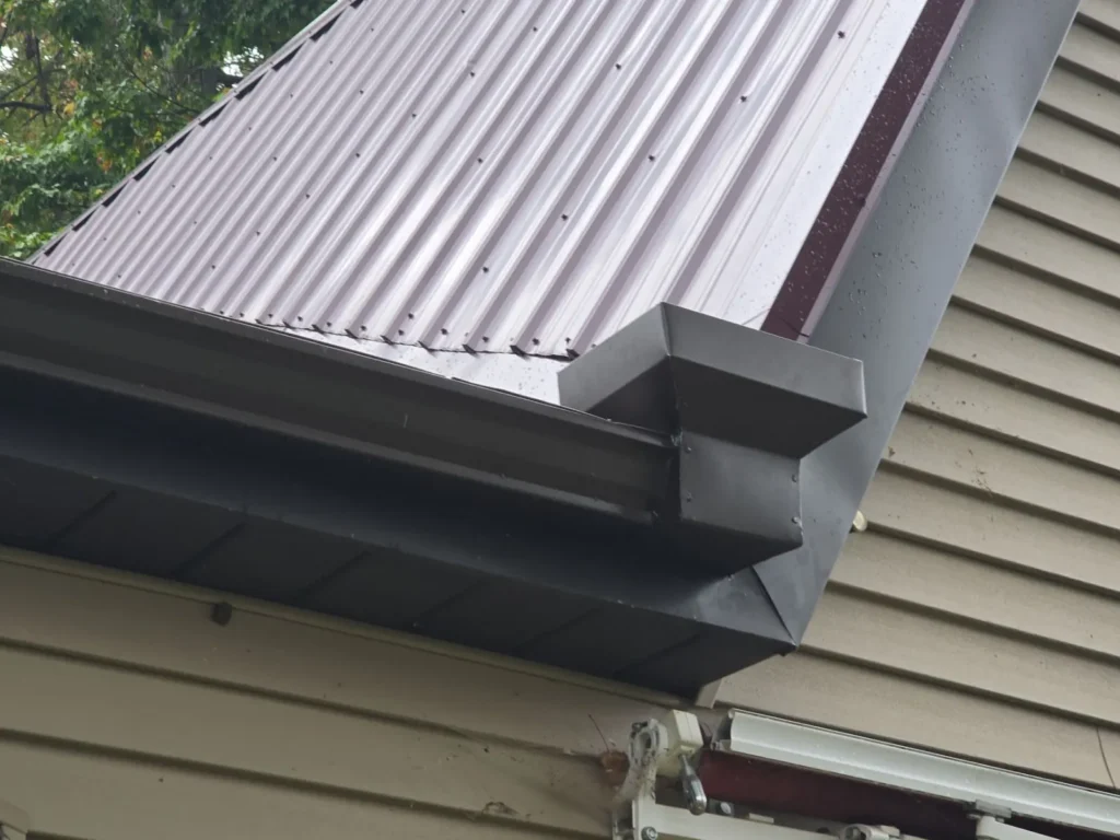 New metal roof with wrapped fascia and seamless gutter installed by Stoney Creek Construction in Hudson, Indiana