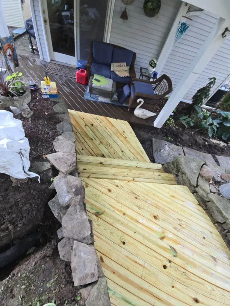 New pressure-treated deck walkway with stone border by Stoney Creek Construction in Rome City, Indiana